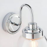 Close-up of Endon Bramworth bathroom wall light showing polished chrome wall plate, curved arm, and clear glass shade fitting with E14 bulb.