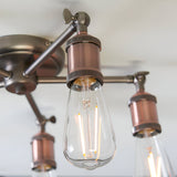 Close-up of Endon Brackley 5 light semi-flush ceiling light in pewter and copper finish, with adjustable arms and exposed E27 filament bulbs.