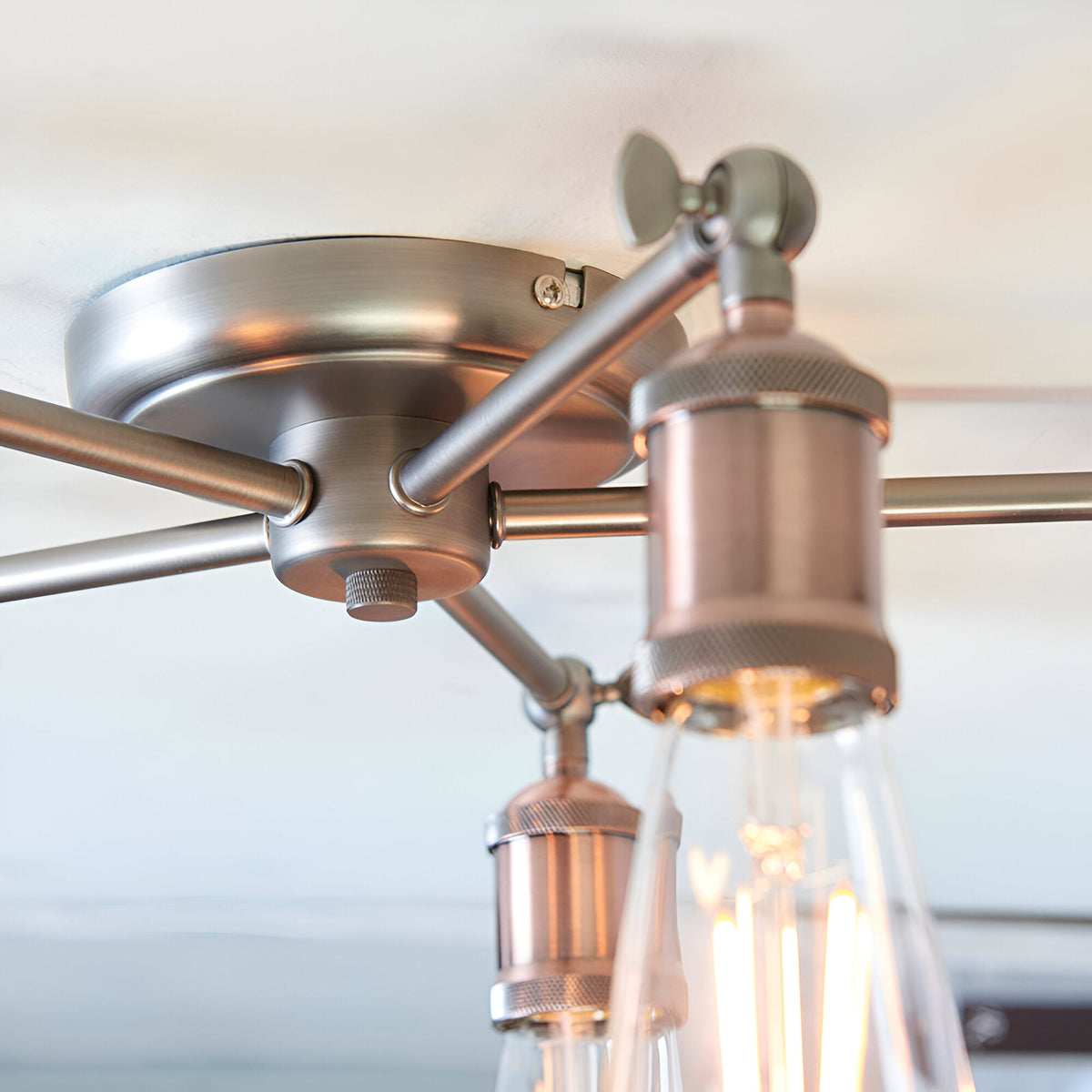 Close-up of the Endon Brackley 5 light semi-flush ceiling light, showing the pewter ceiling plate and copper E27 lamp holders with exposed bulbs.