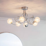 Endon Sabine six-light semi-flush ceiling light in chrome with swirling steel arms and glass globe shades, mounted in a room above a round mirror.