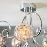 Close-up of the Endon Sabine semi-flush ceiling light in chrome, showing a glass globe shade with internal wire detail and curved chrome arms.