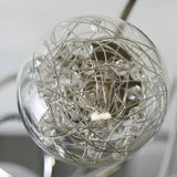 Close-up of one glass globe from the Endon Sabine semi-flush ceiling light, showing chrome wire coils and crystal beads around a G9 lamp.