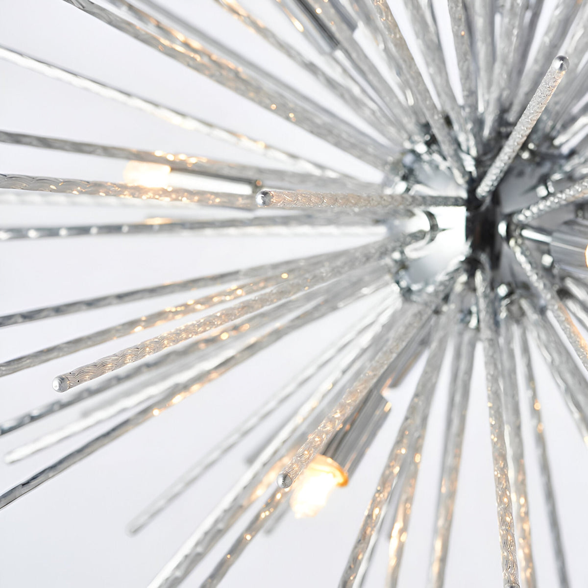 Close-up of Endon Caldleigh 9 light pendant showing textured polished chrome starburst rods radiating from a central chrome hub with G9 lamps.