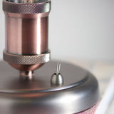 Close-up of Endon Brackley table lamp base showing aged copper cylindrical holder with knurled detailing and pewter toggle switch on brushed metal base.