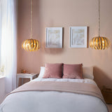 Endon Colette 3 light pendants in gold leaf with layered leaf shades, hung as a pair on chains above a bed in a soft pink bedroom.