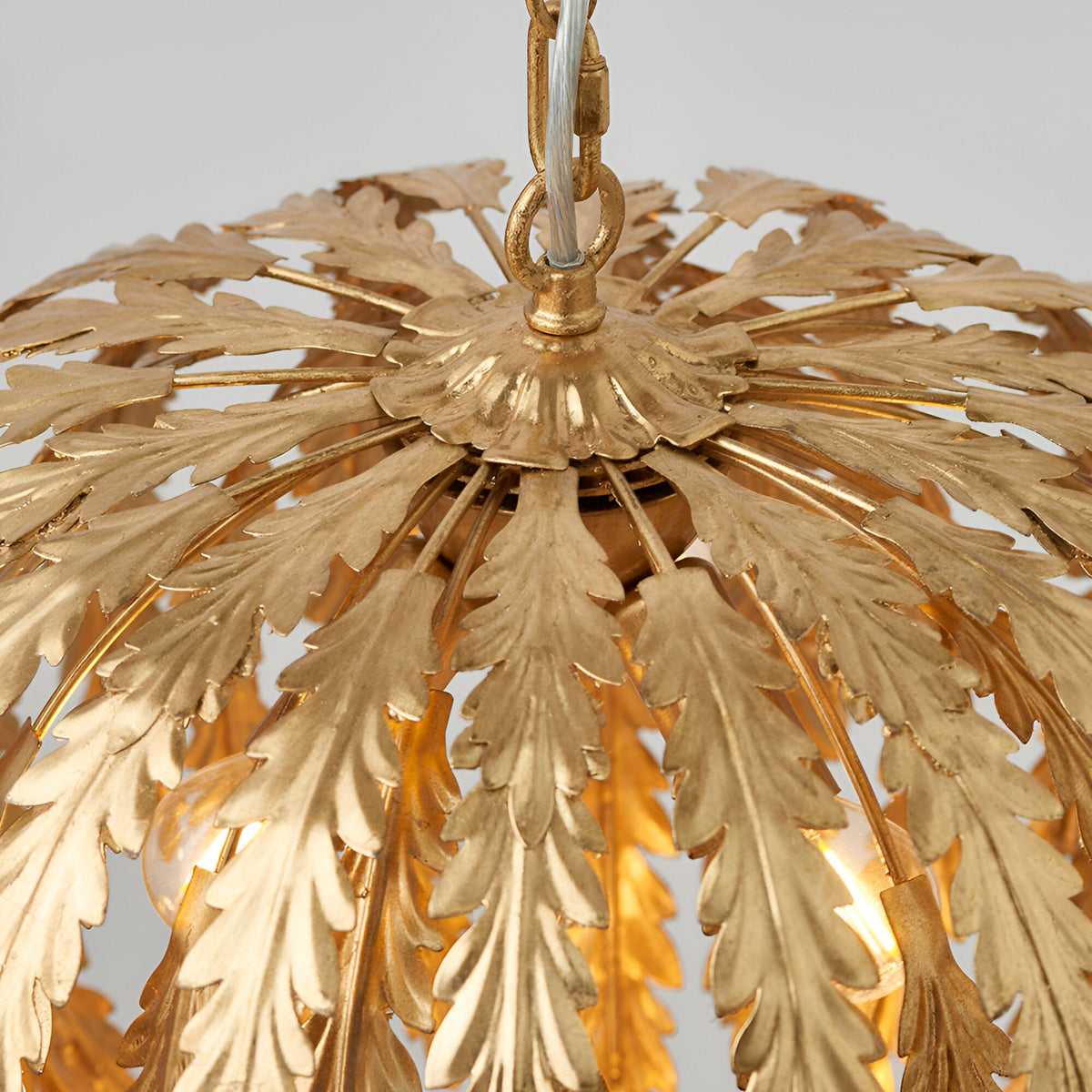 Close-up of the Endon Colette 3 Light Pendant in gold, showing layered gold leaf foliage fanning from the chain suspension over lit E14 lamps.