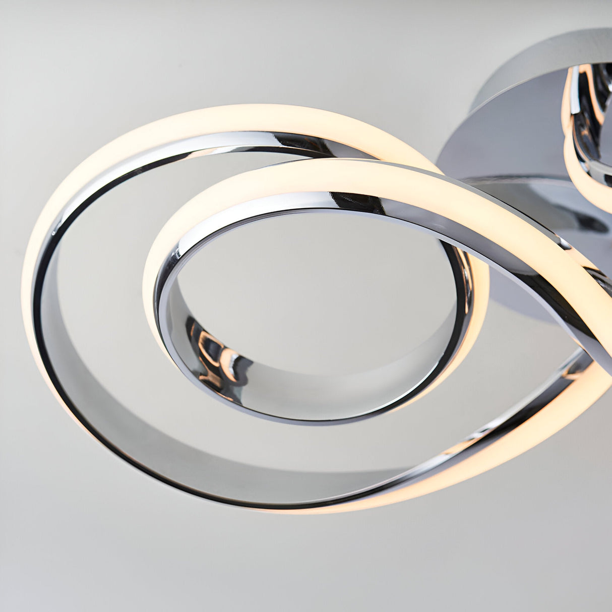Close-up of the Endon Neve semi-flush ceiling light showing interlocking polished chrome loops with integrated warm white LED strips.