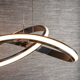 Close-up of Endon Neve pendant light in chrome, showing the looped sculptural band with a white LED diffuser, suspended by thin wires against grey wall.