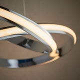 Close-up of the Endon Neve pendant light showing flowing chrome curves with an illuminated white diffuser casting a warm glow.
