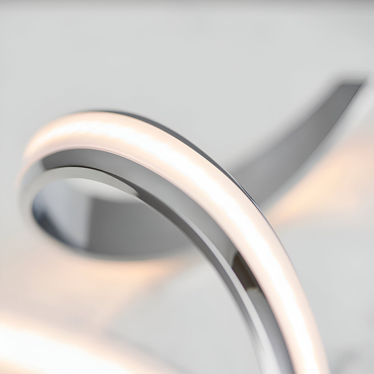 Close-up of the Endon Neve table lamp showing its polished chrome curves and illuminated white diffuser band.