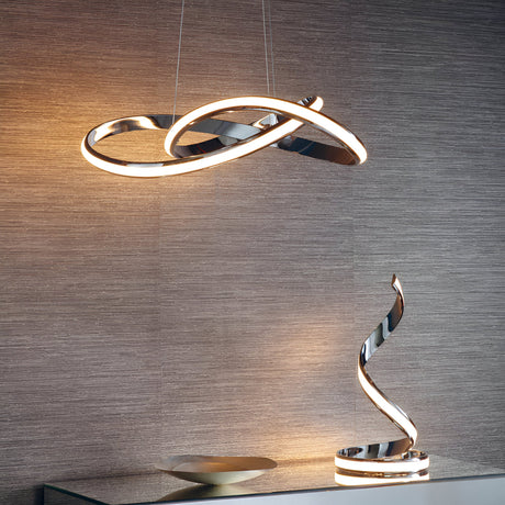 Endon Neve chrome table lamp with a twisting sculptural form and integrated LED, shown on a glass shelf beneath a matching curved pendant light.