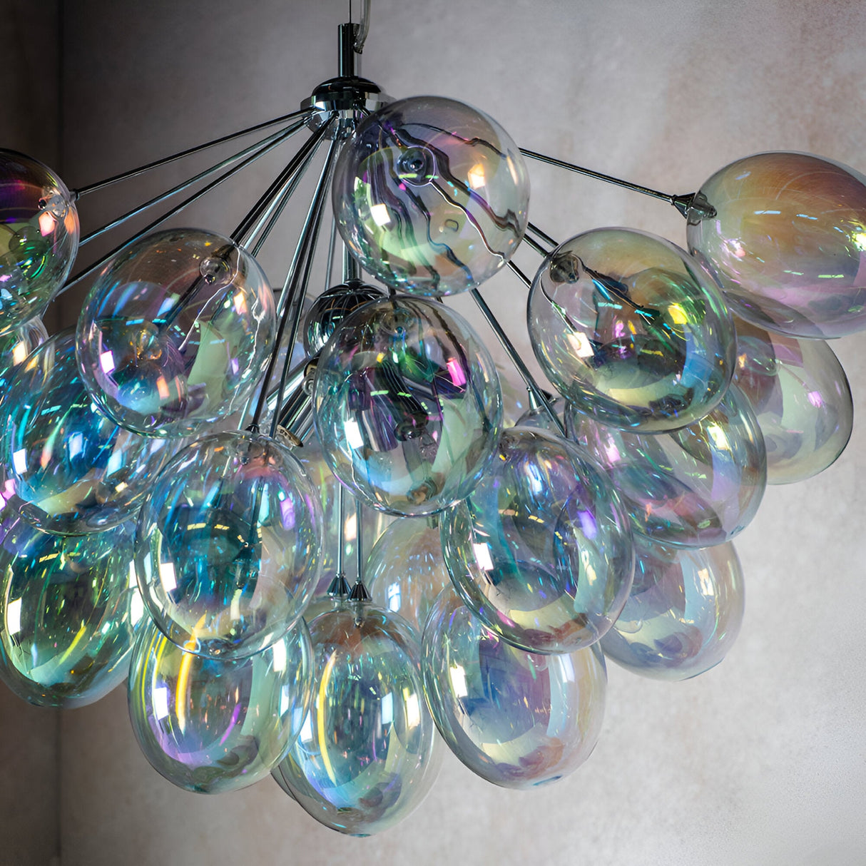 Endon Brenworth 6 light pendant in chrome with a cluster of iridescent glass globe shades reflecting shifting colours against a neutral wall.