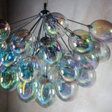 Endon Brenworth 6 light pendant in chrome with a cluster of iridescent glass globe shades reflecting shifting colours against a neutral wall.