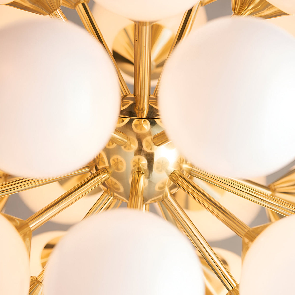 Close-up of the Fitzroy 28 Light Pendant in brushed brass, showing radiating arms and round white opal glass globes in a sunburst cluster.