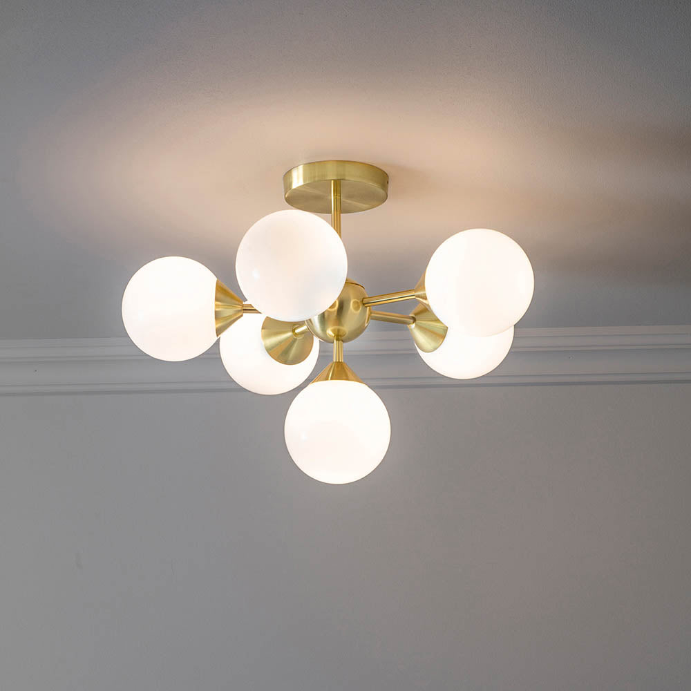 Fitzroy 6 Light Semi-Flush Ceiling Light in gold, featuring brass arms with six round opal glass globes, mounted on a grey ceiling.