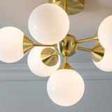 Fitzroy 6 Light Semi-Flush Ceiling Light in gold, brass fitting with cone-shaped arms holding six round opal glass globes.