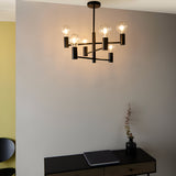 Endon Marlowe 6 light semi-flush ceiling light in matt black metal with six arms and clear globe bulbs, shown above a dark console in a grey room.