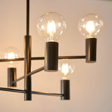 Close-up of Endon Marlowe 6 light semi-flush ceiling light in matt black, showing cylindrical arm ends holding lit E27 globe bulbs.