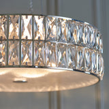 Close-up of the Marguerite LED Round Pendant in chrome, showing two tiers of faceted crystal panels around a glowing frosted glass diffuser.