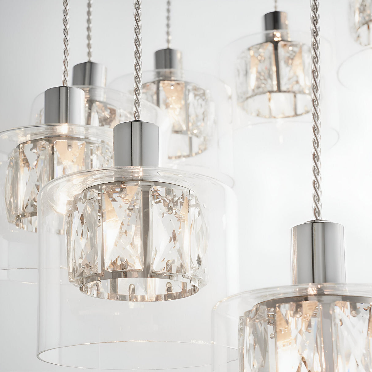Marguerite 12-light pendant in polished chrome with faceted crystal shades on braided cables, shown close-up against a white background.