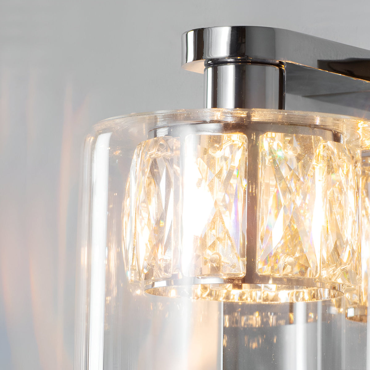 Close-up of Endon Marguerite chrome wall light showing faceted crystal shade within a clear glass diffuser and polished chrome fitting.