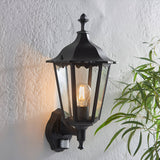 Endon Ashshaw traditional outdoor wall lantern in matt black die-cast aluminium with clear glass, E27 filament bulb and PIR sensor, on a white wall.