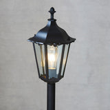 Endon Ashshaw bollard light in matt black die cast aluminium with a traditional lantern head, clear glass panels and a visible E27 filament bulb.