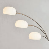 Endon Brockcombe 3 light floor lamp with three arched satin nickel arms and white glass shades against a light grey background.