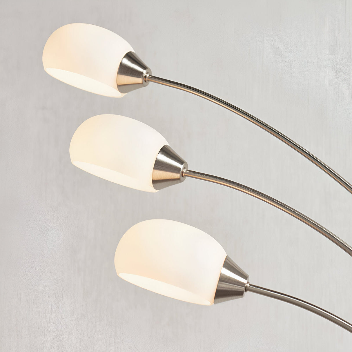 Endon Brockcombe 3 light floor lamp with satin nickel arched arms and white glass shades, shown in close-up against a light grey background.