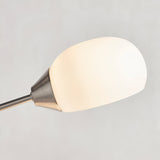 Close-up of the Endon Brockcombe floor lamp's white glass shade on a satin nickel arm, shown against a plain light grey background.