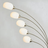 Brockcombe 5 Light Floor Lamp in satin nickel, five arched arms with white glass shades emitting warm light, shown against a plain light grey background.