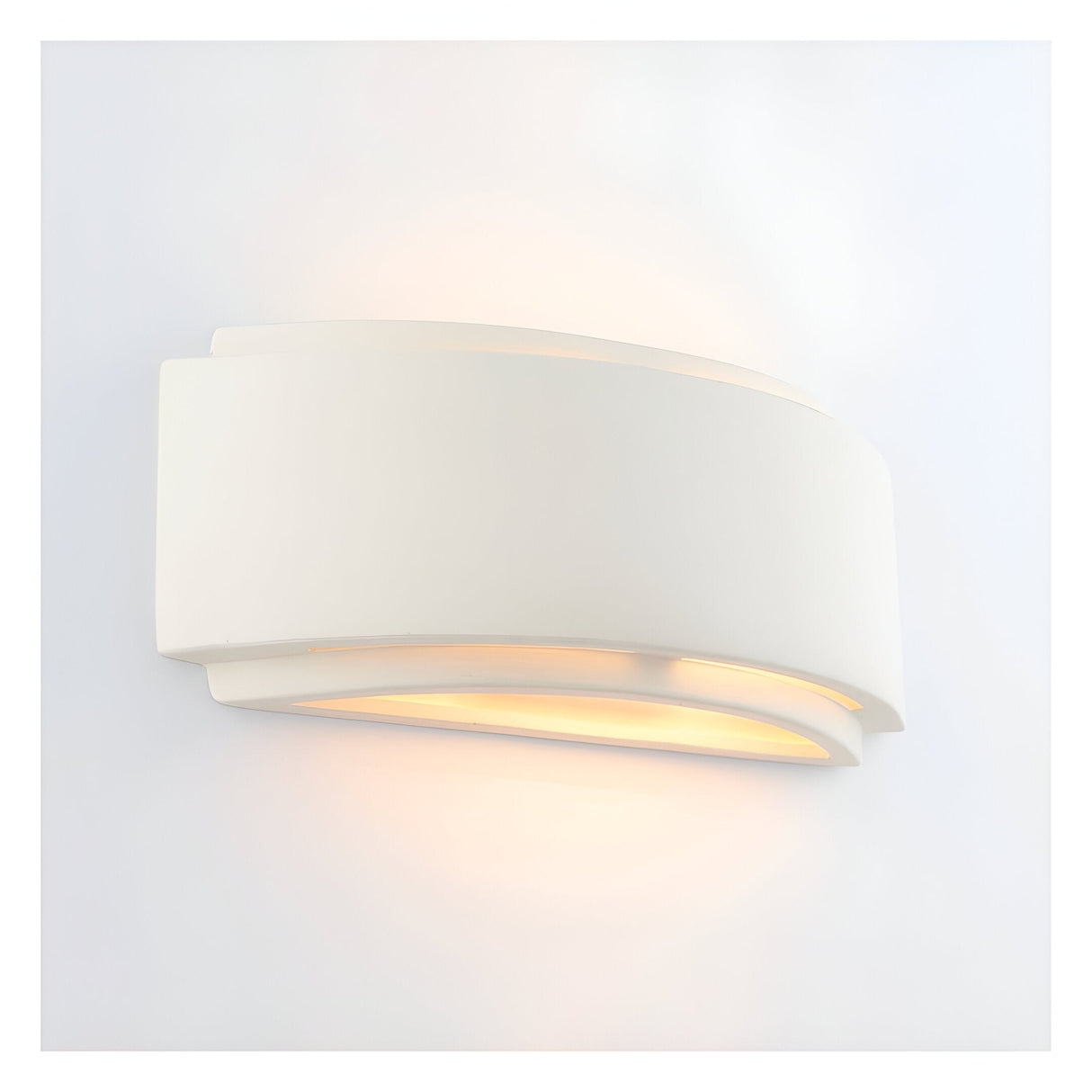 Endon Bramhurst wall light in un-glazed white ceramic, curved rectangular form casting a warm up-and-down glow against a plain white wall.