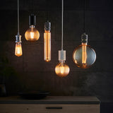 Endon Camden pendant lights grouped over a kitchen counter, showing brass and black cable fittings with exposed filament LED bulbs against dark slate tiling.