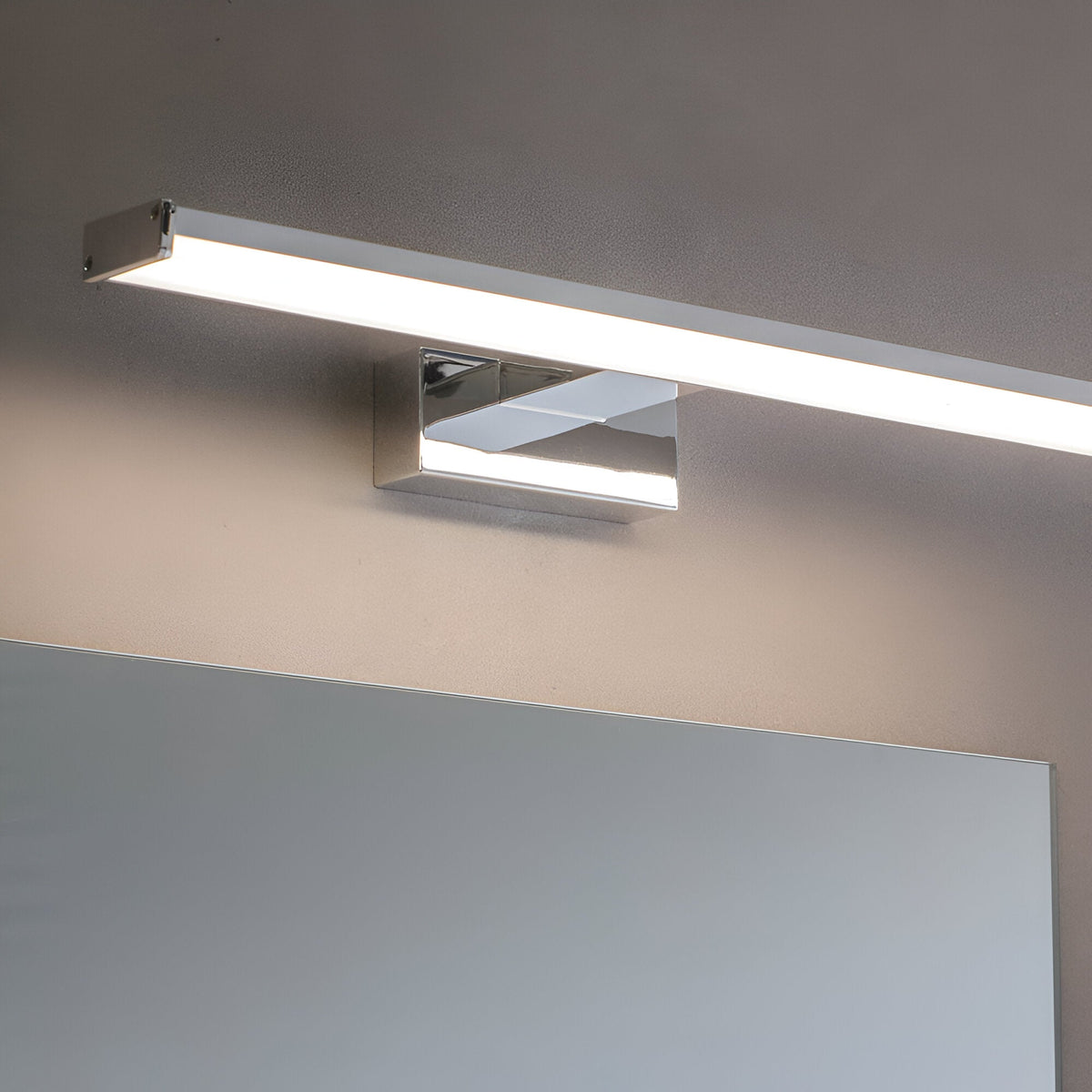 Endon Aldshaw LED bathroom wall light in chrome with a slim frosted diffuser bar, mounted above a mirror on a neutral wall.