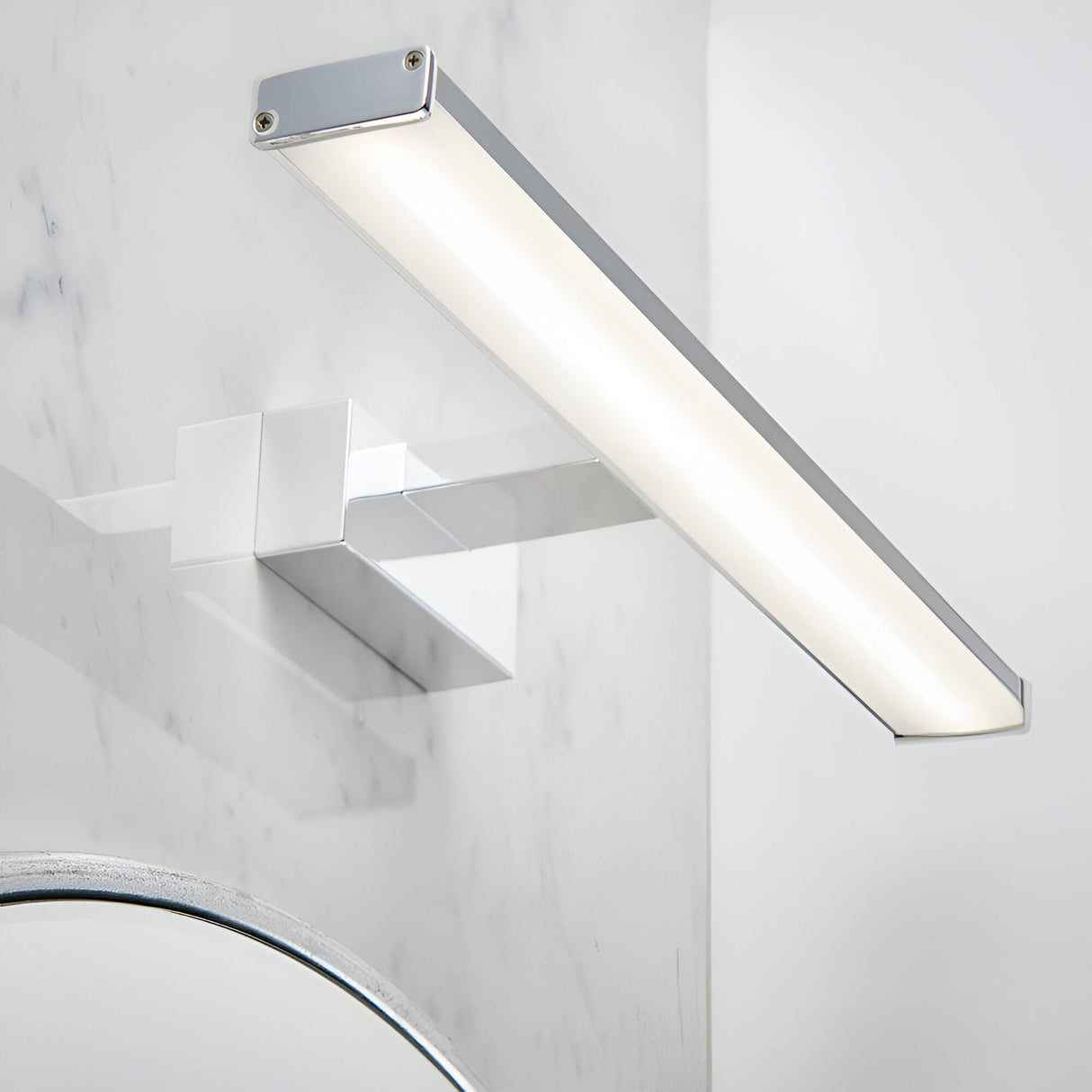 Endon Aldshaw LED bathroom wall light in chrome with a slim frosted diffuser bar, mounted on a marble wall above a chrome tap and mirror.