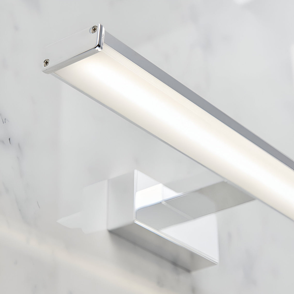 Endon Aldshaw LED bathroom wall light in chrome, close-up of the slim frosted diffuser bar and square wall bracket mounted on a marble wall.