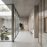 A modern minimalist hallway with concrete floors, large glass walls, potted plants, a rock garden courtyard outside, and Micro LED Pendant Light - White featuring adjustable LED lighting hanging from the ceiling.