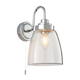 Endon Aldhurst bathroom wall light in chrome with a curved arm, clear glass bell shade, E14 filament bulb and pull cord switch, on a white background.