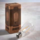 Endon 2W E27 LED filament pear bulb in clear glass with visible warm-tone filaments, lying beside its printed kraft retail box on a light surface.