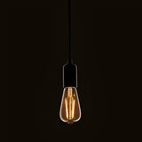 Endon 2W E27 LED filament pear bulb with amber tinted glass, suspended from a black pendant cord and matte black lampholder against a dark background.