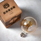Endon 2W E27 LED amber globe filament bulb, 125mm tinted glass with visible filament and screw cap, beside its printed kraft box on a light background.