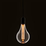 Pendant light with clear oversized E27 LED globe bulb, warm white glowing filament, black cord and fitting, dark background.