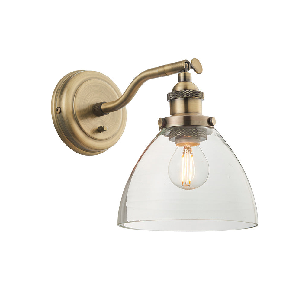 Wentworth Wall Light in brass with adjustable knuckle arm, knurled lamp holder, clear dome glass shade and exposed bulb, shown on a plain white background.