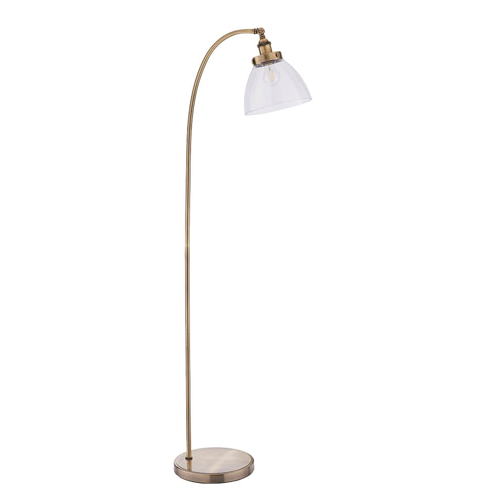 Endon Wentworth floor lamp in antique brass with an arched stem, clear glass dome shade, knurled lamp holder and round base, shown on white.
