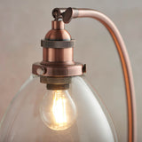 Endon Wentworth table lamp close-up showing copper knurled lamp holder, adjustable knuckle, clear glass shade and lit E14 filament bulb.