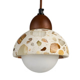 The Terroso 1 Light Dome Travertine Single Pendant Light in Walnut Brown & Light Beige features a terrazzo-patterned dome, wooden accent, frosted glass globe shade, and brown cord for a modern look.