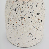 Close-up of the Endon Crangrove table lamp's white terrazzo base, showing matt speckled composite with black, grey and warm brown aggregate flecks.