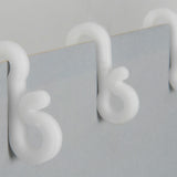 Close-up of LYYT Gutter Hooks from AVSL, white UV-resistant plastic clips shown fitted over the lip of a light grey gutter edge.