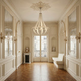 A bright, elegant hallway with ornate cream walls, large mirrors, carved moldings, parquet wood flooring, a decorative fireplace, a built-in white bench near tall windows, and a Tessaro LED K9 Crystal & Leather Small Chandelier in white.