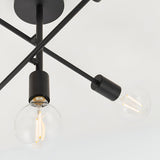 Close-up of the Endon Marlowe 5 Light Semi-Flush Ceiling Light in black, showing crossed metal arms with exposed E27 globe bulbs against a white ceiling.